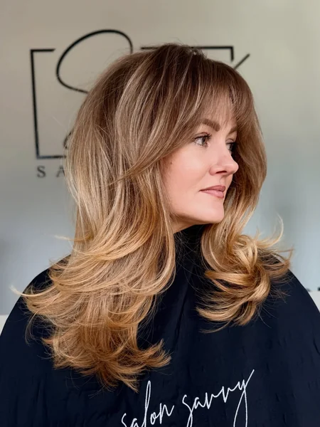 Layered Blonde Blowout with Curtain Bangs