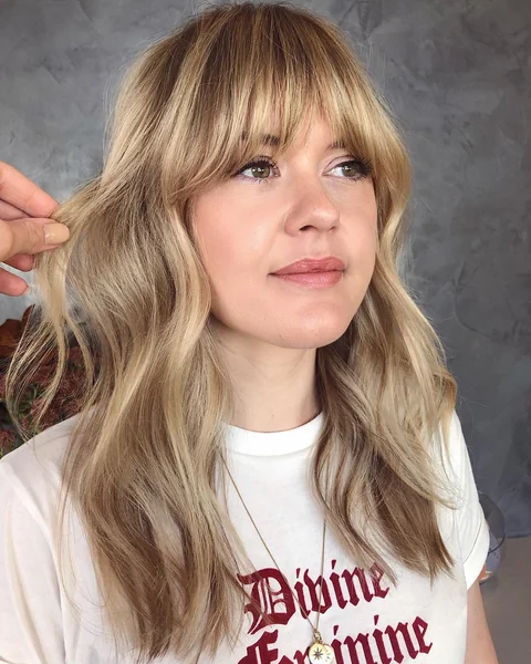 Medium Blonde Wavy Hair with Curtain Bangs