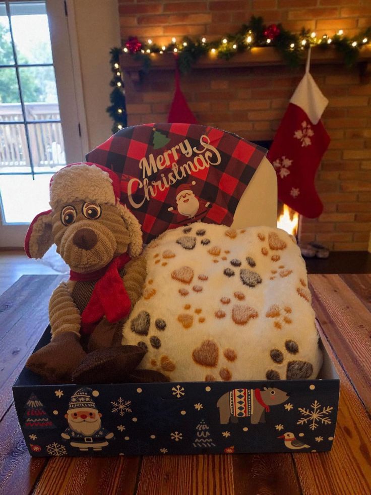 This may contain: a dog sitting on top of a cake in a box next to a christmas tree