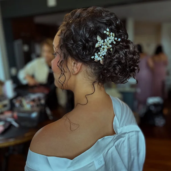 Elegant Dark Curly Updo with Pearl Hair Clip