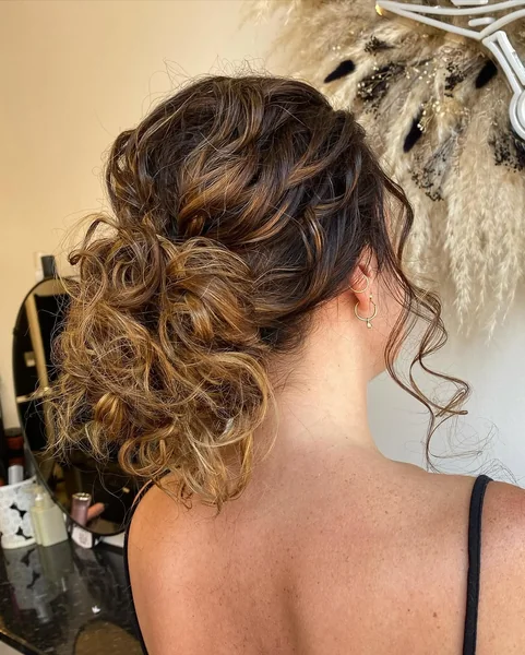 Romantic Low Bun with Caramel Highlights and Loose Curls
