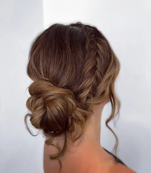 Braided Blonde Low Bun with Volume and Soft Curls