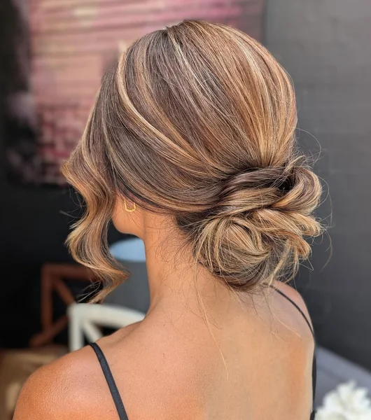 Chic Sun-Kissed Low Bun with Elegant Face-Framing Waves