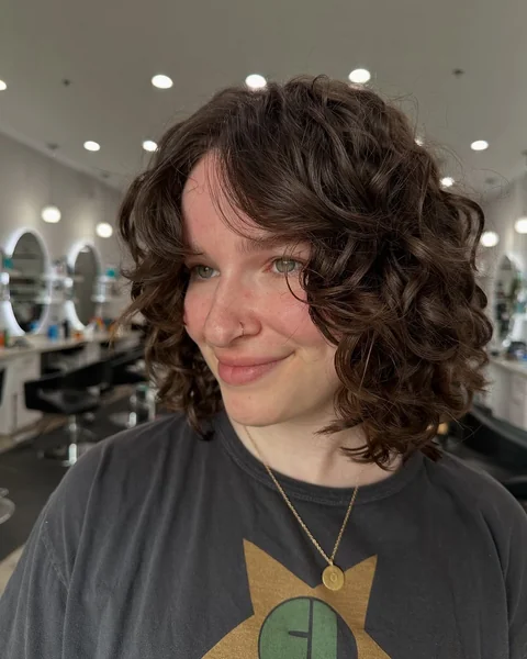 Deep Brunette Curly Bob with Side-Swept Volume