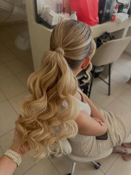 Dramatic Blonde Hollywood Waves in a Mid-Height Ponytail