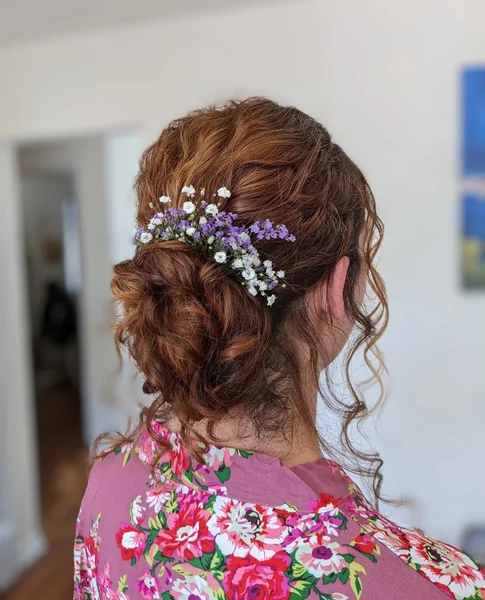 Floral-Adorned Auburn Messy Bun for Special Occasions