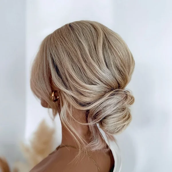 Low Textured Blonde Chignon with Soft Face-Framing Wisps