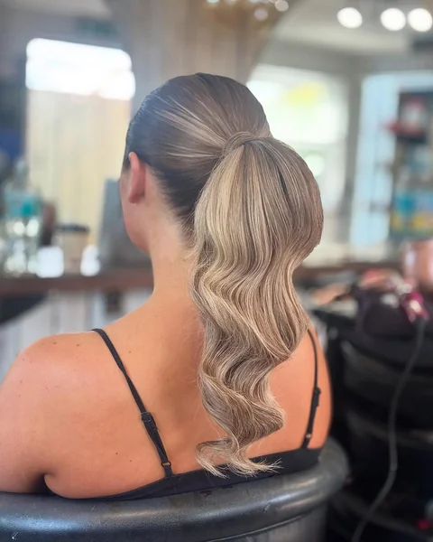 Messy Low Ponytail with Face-Framing Curtain Bangs