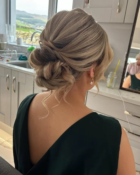 Sophisticated Twisted Low Bun with Face-Framing Tendrils