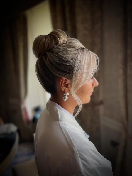 Voluminous Blonde Top Knot with Romantic Face-Framing Tendrils
