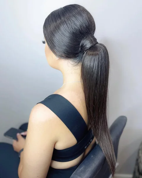 Voluminous Low Ponytail with Soft Waves and Lifted Crown