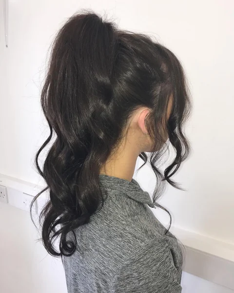 Voluminous Wavy High Ponytail with Face-Framing Tendrils